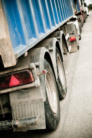 Dirty trucks stand in line from behindの写真素材