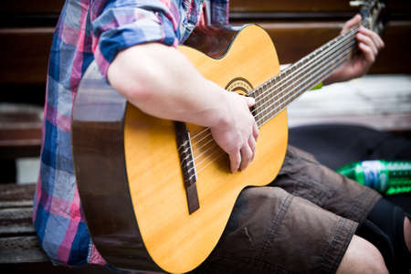 Musician playing guitar on city street