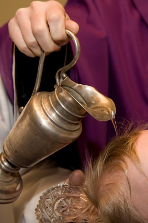 child`s head priest pours waterの写真素材