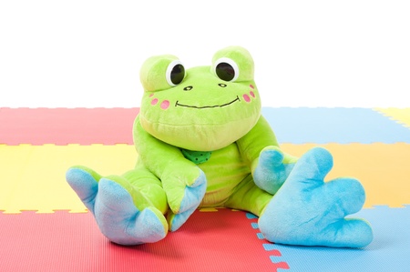 green plush frog sitting on the floorの写真素材