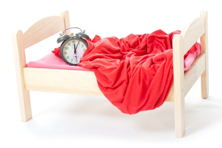 smal clock in small bed on white backgroundの写真素材