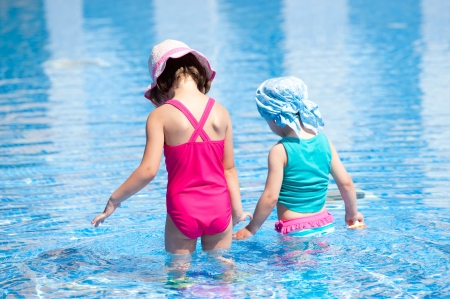 little girls playing in the pool on holidayの写真素材