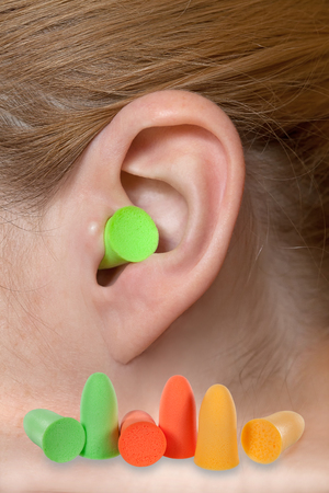 Green ear plug into the earの写真素材