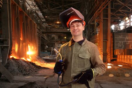 Portrait of a happy male welder standing against the foundryの写真素材