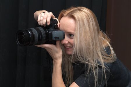 female photographer taking pictures indoorsの写真素材