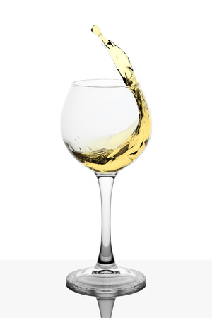 Splash of white wine in the cup filling on a white backgroundの写真素材