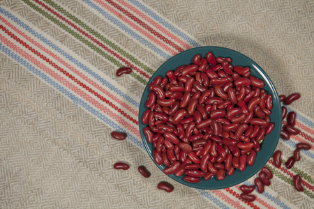 Red beans in a green plate on a homespun napkin