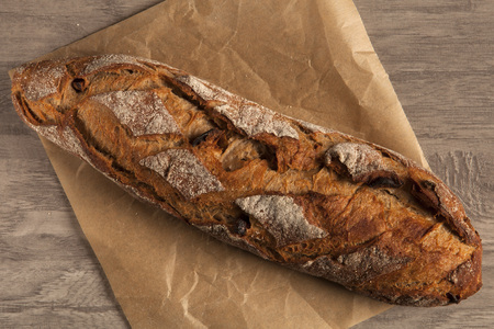 Wheat loaf with dried apricots on a wooden board