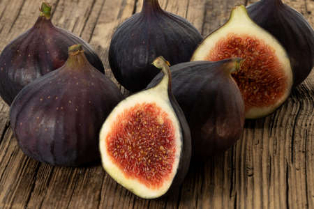 Several whole and half figs on old woodの写真素材