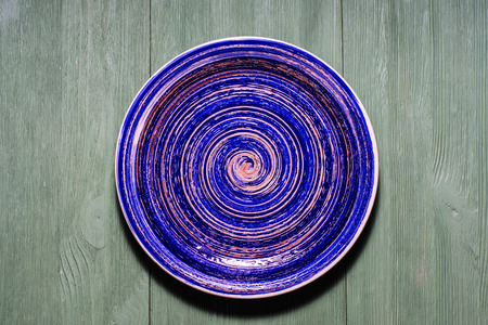 Ceramic plate on wooden background.