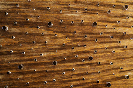Metal cylinders of different shapes on a brown wooden background.
