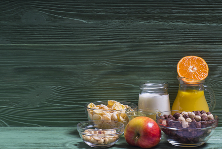 Ingredients for a healthy breakfast: orange juice, yogurt, corn flakes, nuts, honey, tangerines and apples.の写真素材