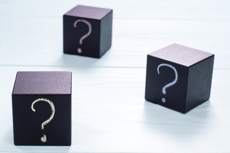 Question mark on black wooden cubes. Cubes with question sign on blue wooden background.の写真素材
