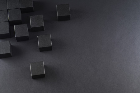 Black wooden cubes on a black background, top view. Abstract background with cubes with copy space.の写真素材