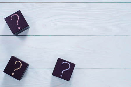 Question mark on black wooden cubes, top view. Cubes with question sign on blue wooden background, flat lay.の写真素材