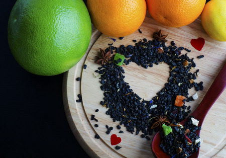 Heart of dried petals of green tea  with fresh fruitの写真素材