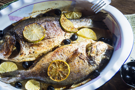 Baked in oven sea fish dorado with lime, olives and onion.
Grilled dorada fish on plate, close-up.の写真素材