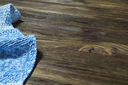 Blue handmade knitted tablecloth from left side wooden table. Blue napkin on wooden table with copy space.の写真素材