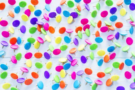 Colorful push pins on blue wooden background, close up. Bright multi-colored thumbtacks.の写真素材