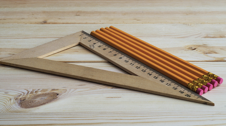 Triangle and pencils on the wooden backgroundの写真素材
