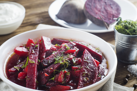 Vegetable soup - red borsch  in a white bowl on a rustic wooden background, clouse up. Healthy beetroot soup, vegetarian food. Delicious beet soup with sour cream.の写真素材