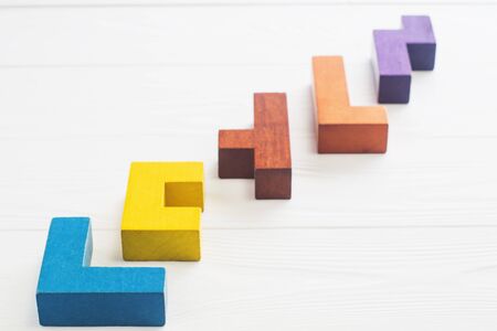 Abstract Background. Different shapes wooden blocks on white wooden background. Geometric shapes in different colors. Concept of creative, logical thinking or problem solving. Copy space.の写真素材