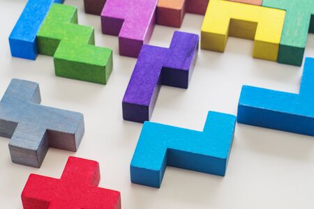 Abstract Background. Different colorful shapes wooden blocks on beige background background, close-up. Geometric shapes in different colors. Concept of creative, logical thinking or problem solving.の写真素材