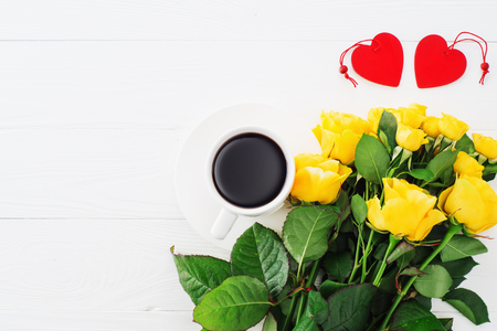 Cup of coffee with bouquet of yellow roses, flat lay, top view. Greeting card template. Floral background for mother's day, wedding invitation, greetings and invitation card. Valentines Day backgroundの写真素材