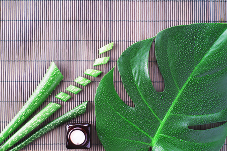 Aloe vera gel with aloe vera leaves on wooden table. Natural cosmetic ingredients. Fresh aloe vera plant on wooden board, flat lay. Spa concept, top view.の写真素材