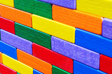 Multicolored wood background. Background with colorful shapes wooden blocks. Colorful wall, toy colored wooden bricks. Multicolor wooden blocks.の写真素材