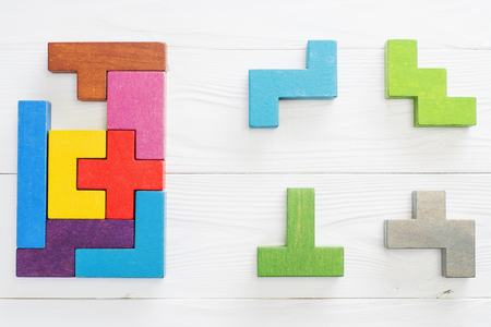 IQ test. Choose correct answer. Logical tasks composed of colorful wooden shapes, top view. Children's educational logical task, flat lay. Visual conundrum, find the missing piece of the proposed.の写真素材