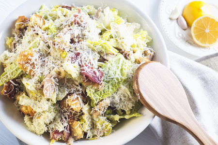 Caesar Salad with on white plate; top view. Delicious Caeser salad with croutons; roasted chicken meat; parmesan cheese and cos lettuce; with sauce; healthy recipe; close-up. Healthy food.の写真素材