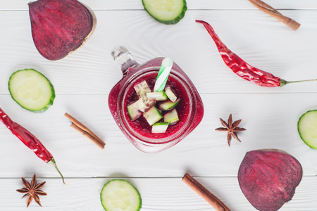 Beetroot smoothie in a mason jar with a straw and ingredients on a wooden background. Fresh beet juice, detox, top view, flat lay. Organic antioxidant smoothies made of beet, apple, cucumber. Healthy vegan raw food.の写真素材