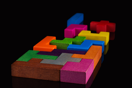 Abstract Background. Different colorful shapes wooden blocks on black background. Geometric shapes in different colors. Concept of creative, logical thinking or problem solving. Copy space.の写真素材