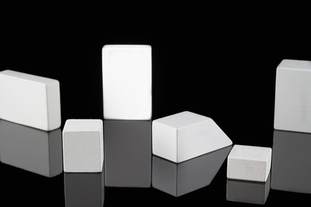 Abstract cubes on black background. White wooden shapes on black with copy space.の写真素材