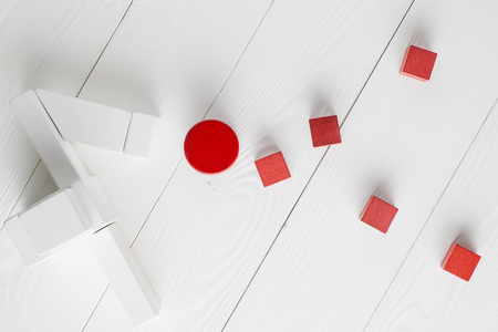 Red and white wooden blocks on white wooden background, top view. Abstract background. Concept of creative, logical thinking. Different geometric shapes wooden blocks on wooden background, flat lay.の写真素材