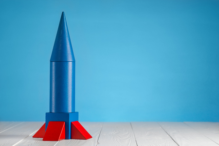 Abstract blue rocket from wooden blocks with copy space. Wooden puzzle in rocket shape, start up concept.の写真素材