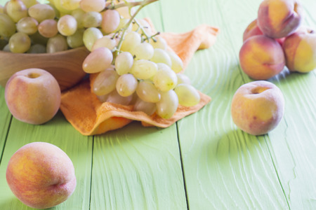 Fresh ripe peaches and grape on wooden background. Healthy Food Background.の写真素材