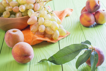 Fresh ripe peaches and grape on a wooden background. Healthy Food Background.の写真素材