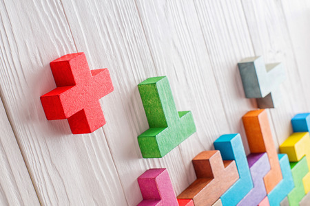 Concept of creative, logical thinking. Different colorful shapes wooden blocks on white wooden background, copy space. Geometric shapes in different colors. Abstract Background.の写真素材