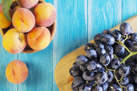 Fresh ripe peaches and red grape on wooden background, top view. Healthy Food Background.の写真素材