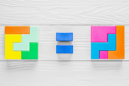Two identical geometric figures composed of different elements. Two figures and a sign between them are equal. The concept of logical thinking. Geometric shapes on wooden background.の写真素材