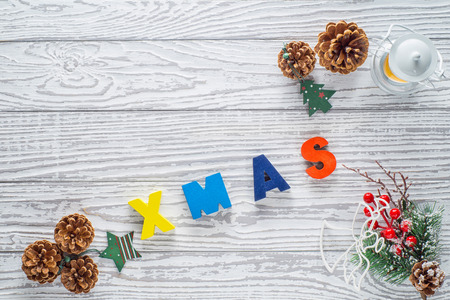 The template for Christmas greetings card with candle lantern, christmas balls, fir twig, cones and Christmas holly on grunge white wooden background with copy space. Xmas and New year concept.の写真素材