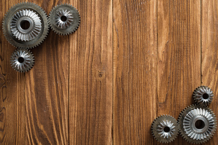 Wooden background with steel gear and reducer. Frame with metal cogwheels, engineering details. Industry Concept.の写真素材
