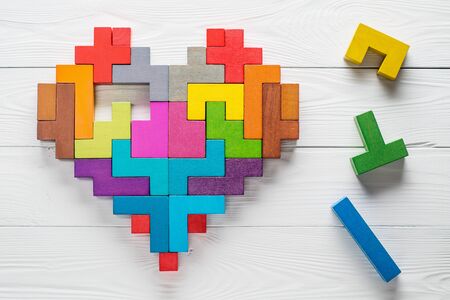 Heart made of colorful wooden shapes, top view, flat lay. Health background concept. Logical tasks. Conundrum, find the missing piece of the proposed.の写真素材