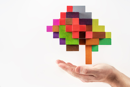 Human hand holding abstract brain. Human brain is made of multi-colored wooden blocks.の写真素材