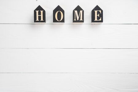 Word home on white wooden background with copy space. Home word concept. Home word written on black wooden houses. の写真素材