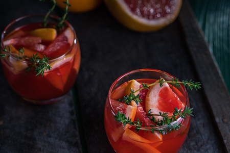 Grapefruit and thyme cocktail. Refreshing drink on rustic background.の写真素材