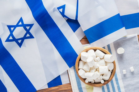 Israel national flags and marshmallows on a wooden background, top view, flat lay.の写真素材