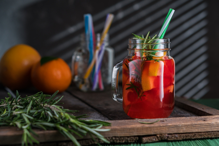 Cocktail with grapefruit and rosemary, long drink. Pink cocktail in mason jar bottle on old dark rustic background.の写真素材